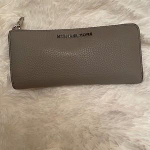 Coach Grey wallet with card slots inside and zipper inside.